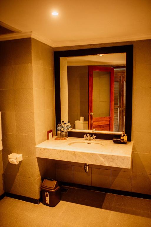 a bathroom with a sink and a large mirror at New Sunari Lovina Beach Resort in Lovina