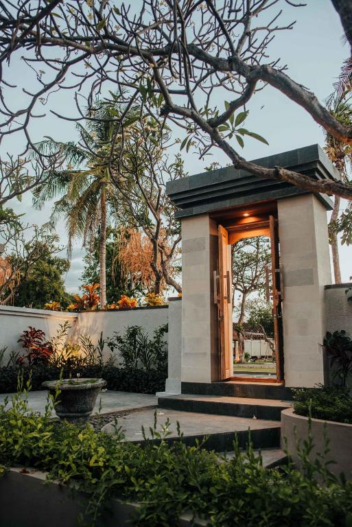 a small building with a window in a garden at New Sunari Lovina Beach Resort in Lovina