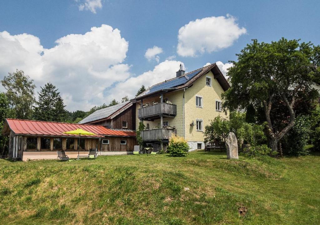 ein großes Haus auf einem Grasfeld in der Unterkunft Ferienwohnung Sigi's Waldhaus in Neuschönau