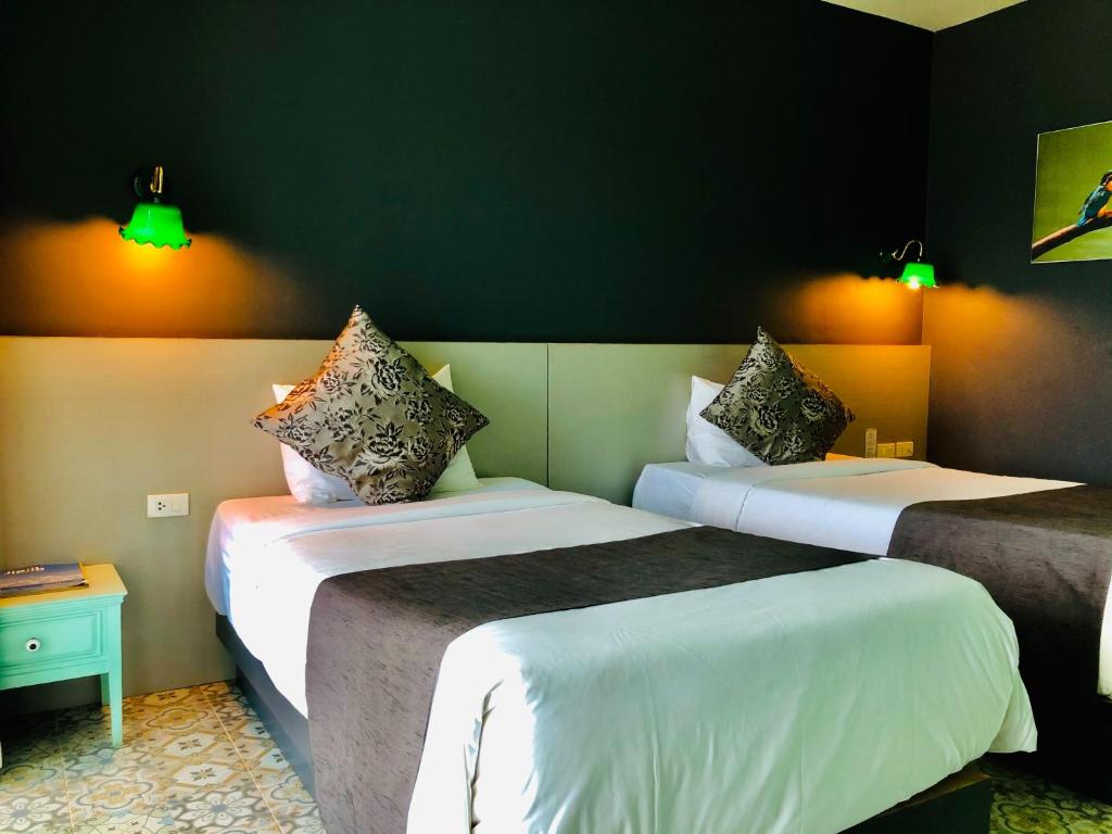 Postel nebo postele na pokoji v ubytování Chiangkhong Teak Garden Riverfront Onsen Hotel- SHA Extra Plus
