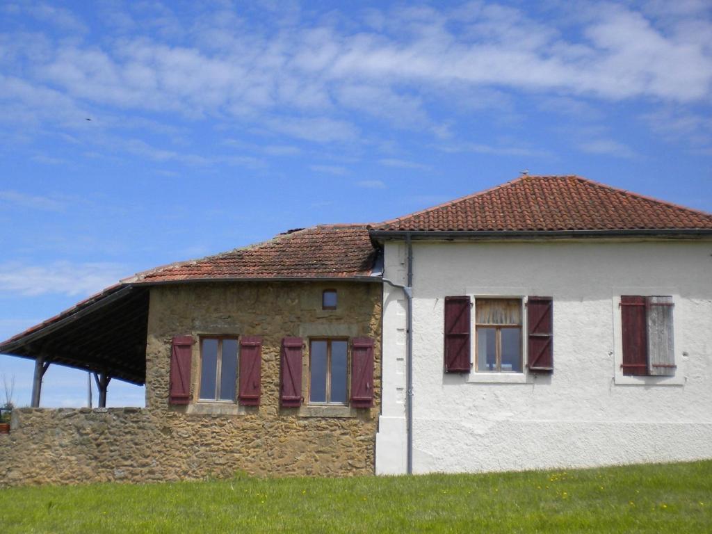 une maison blanche avec un toit rouge sur un champ dans l'établissement Ancienne Ecole, à Cazaux-Villecomtal
