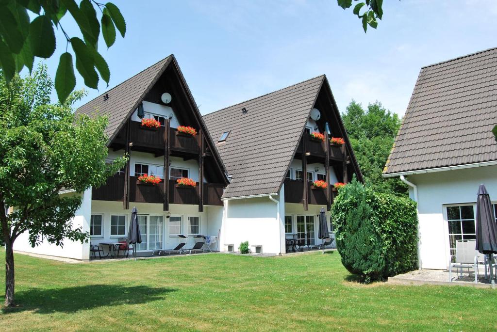 ein großes Gebäude mit zwei Dächern und einem Hof in der Unterkunft Ferienwohnung Stricker Typ A, Balkon 2/3 in Walkenried