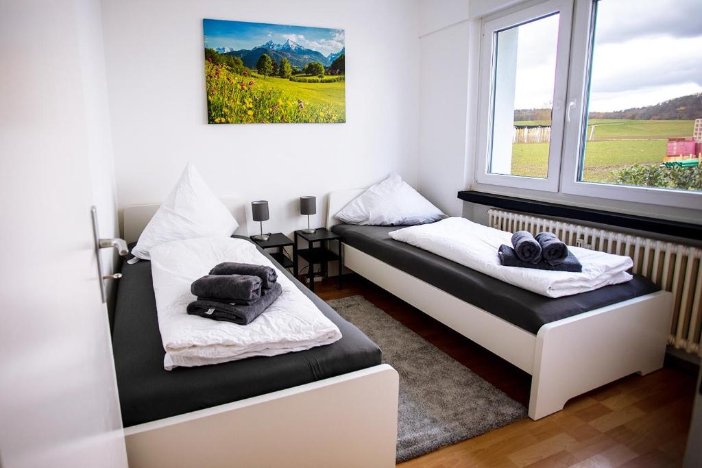 a room with two beds and a window at Schöne 3-Zimmerwohnung mit WLAN in Büsingen