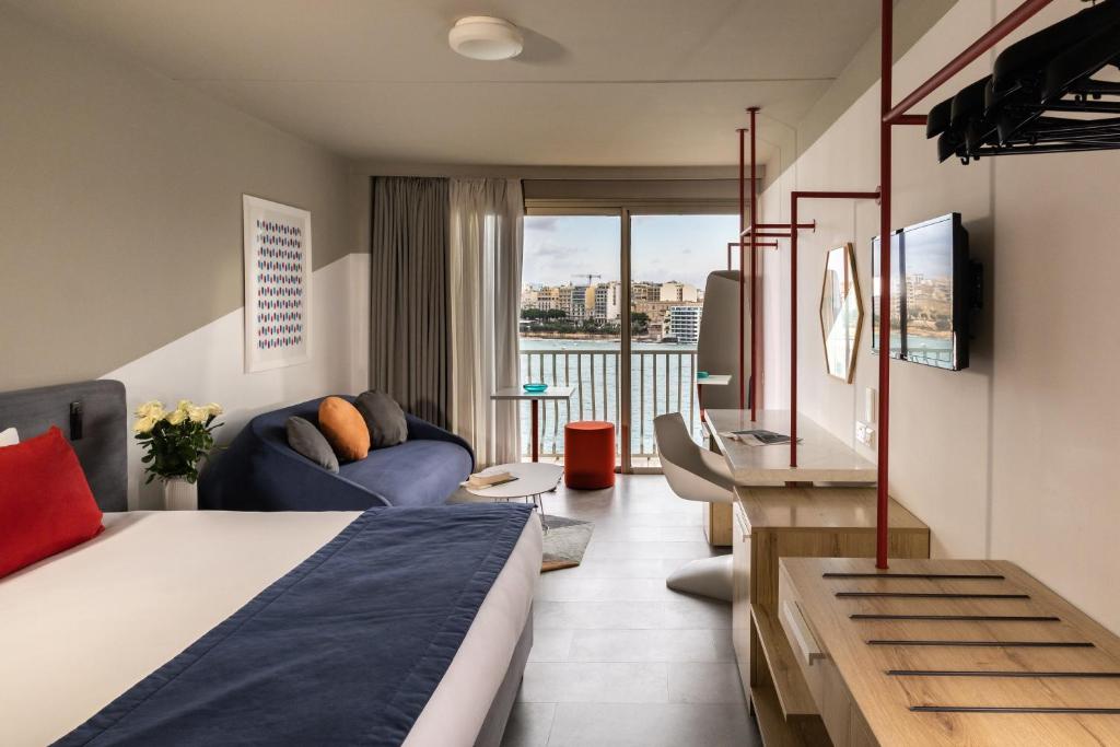 a hotel room with a bed and a tv at Cavalieri Art Hotel in St. Julianʼs