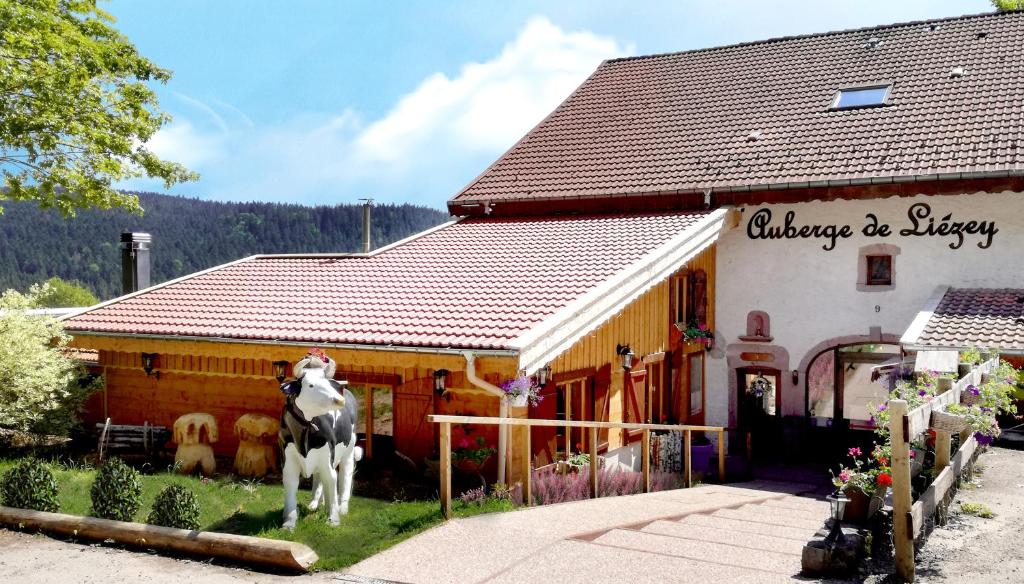 ein Gebäude mit einer Statue einer Kuh davor in der Unterkunft Auberge De Liezey in Liézey