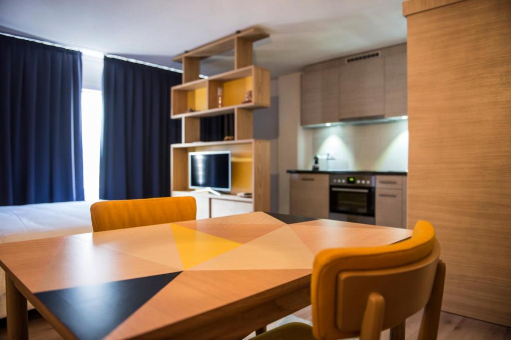 uma cozinha com uma mesa de jantar e cadeiras em GAMA Home em Fribourg