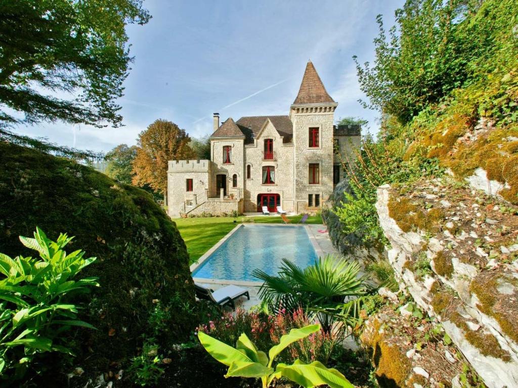 an estate with a swimming pool in front of a house at manoir de la malartrie in Vézac