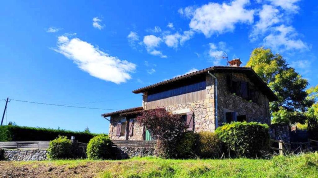 uma casa de pedra com um gato em cima dela em Can Castell de Rocabruna em Camprodon