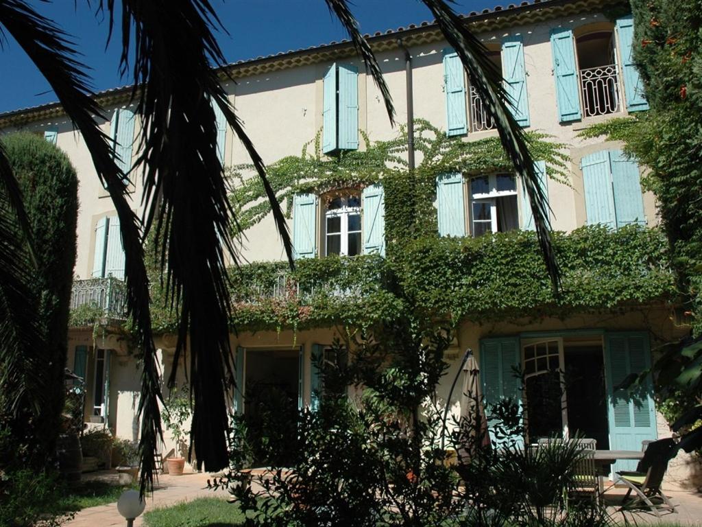 a building with ivy on the side of it at Le Jardin d'Homps in Homps