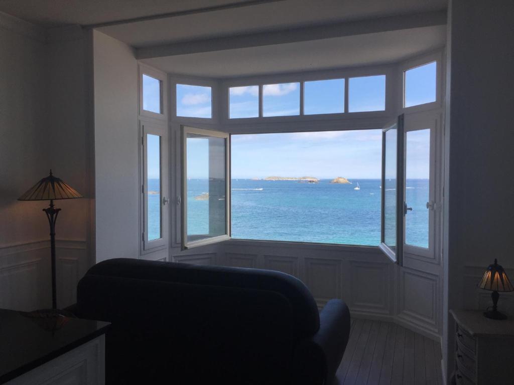 um quarto com uma grande janela com vista para o oceano em Villa XIXe Vue mer em Dinard