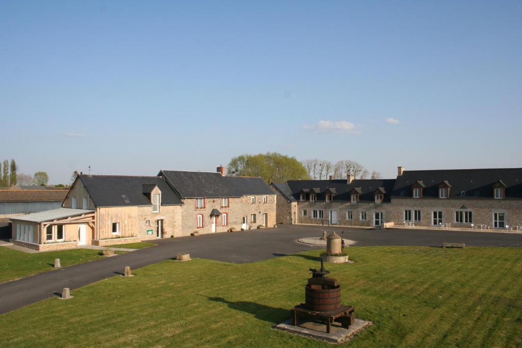 a group of buildings with a grassy field in front at Etoile des Grèves in Ardevon