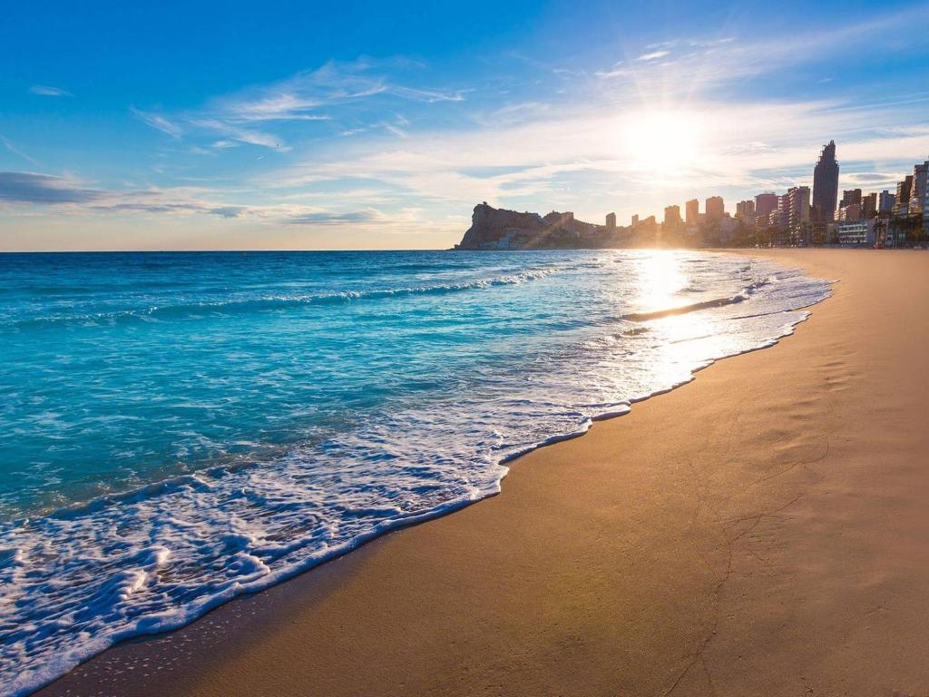 una playa con el océano y una ciudad en el fondo en Apartamento Benidorm 3, en Benidorm