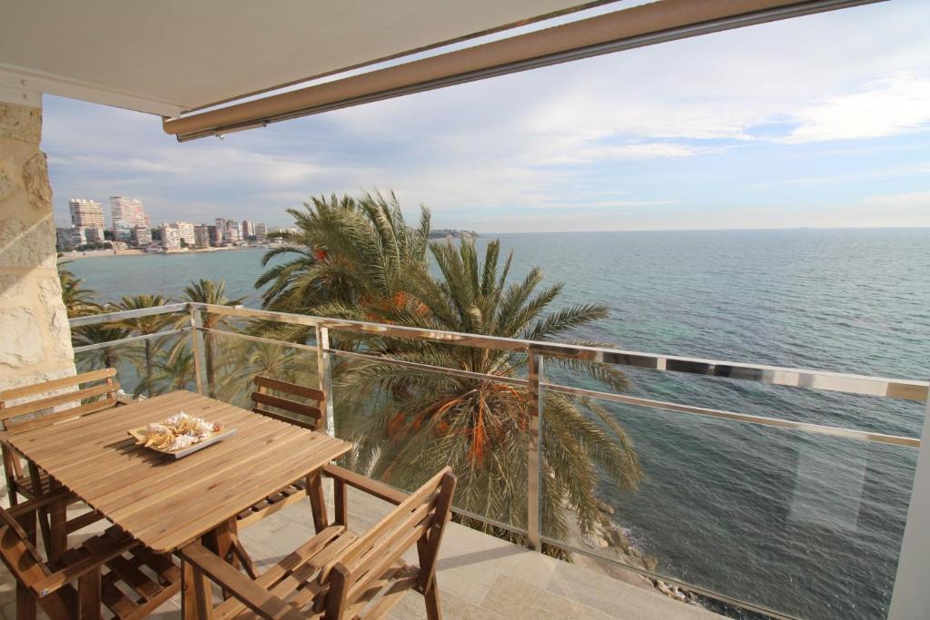 a balcony with a table and chairs and the ocean at Apartamento Voramar in Alicante