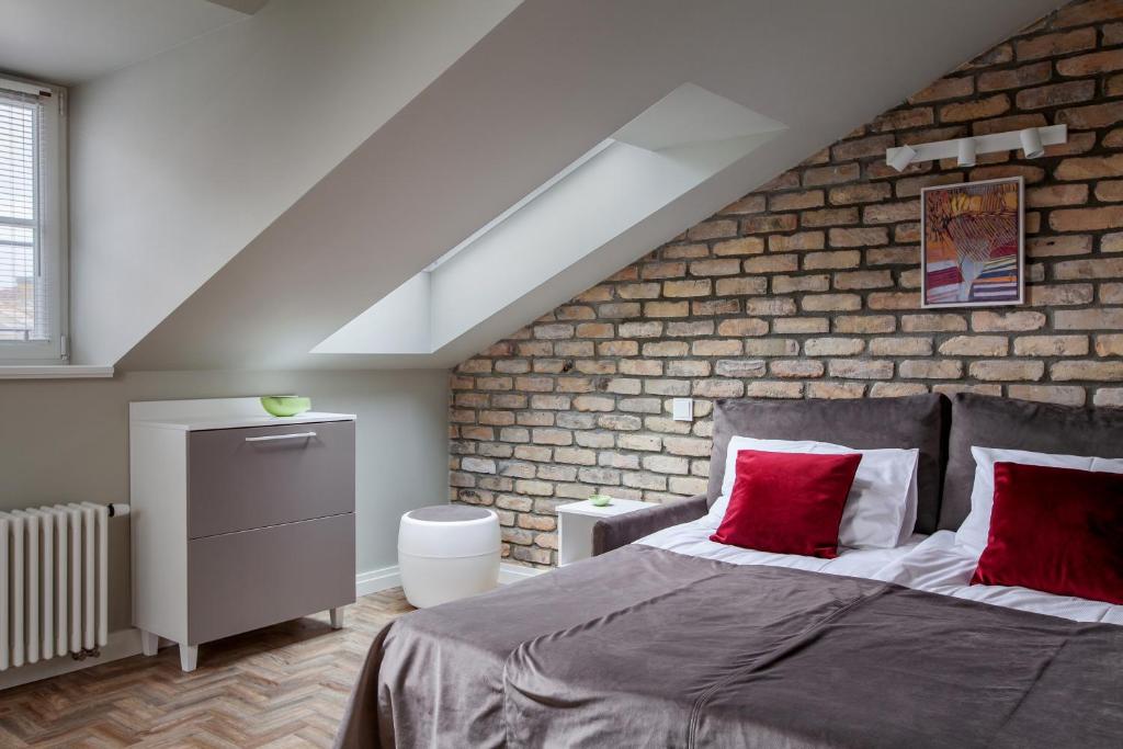 a bedroom with a bed and a brick wall at Somnia Apartments in Vilnius