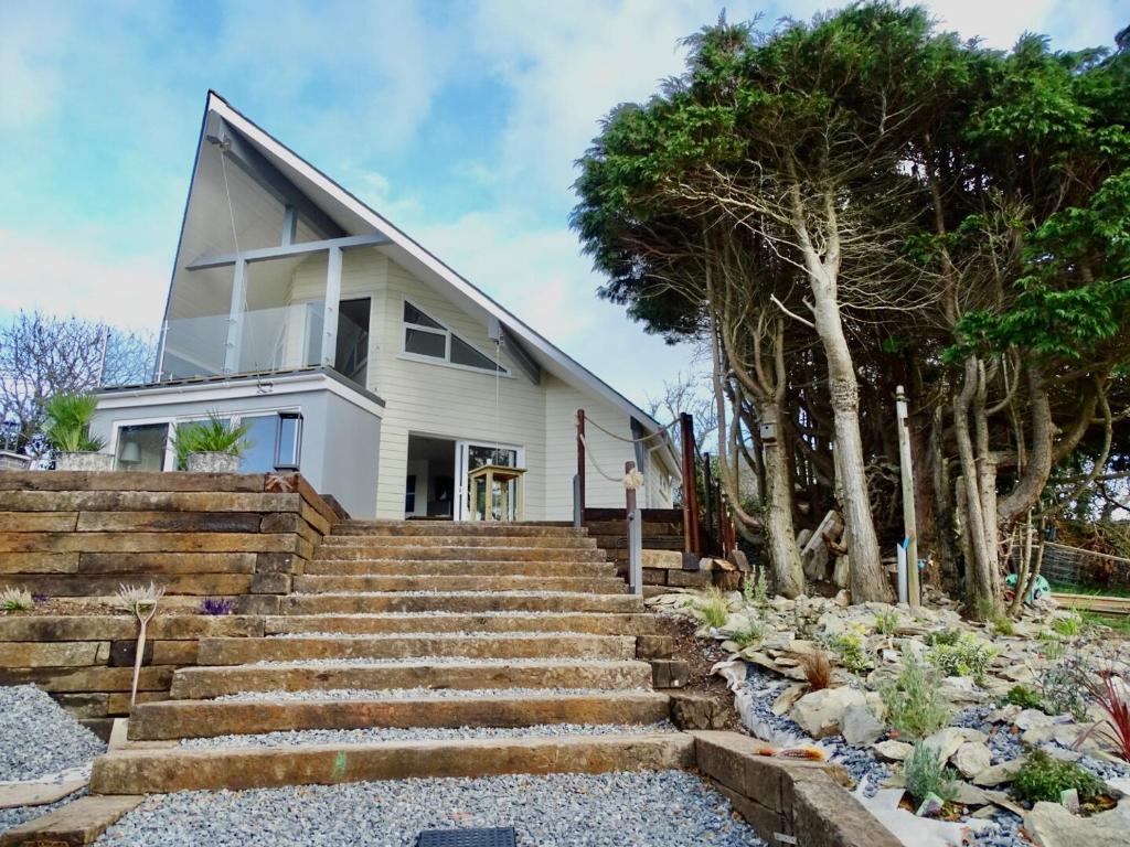 Casa blanca con escaleras y árboles en The Kite, Upper Torrs View, en Ilfracombe