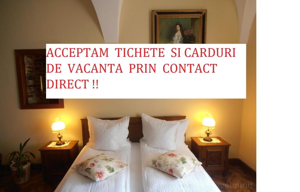 twee bedden in een hotelkamer met twee lampen bij Gothic House in Sibiu