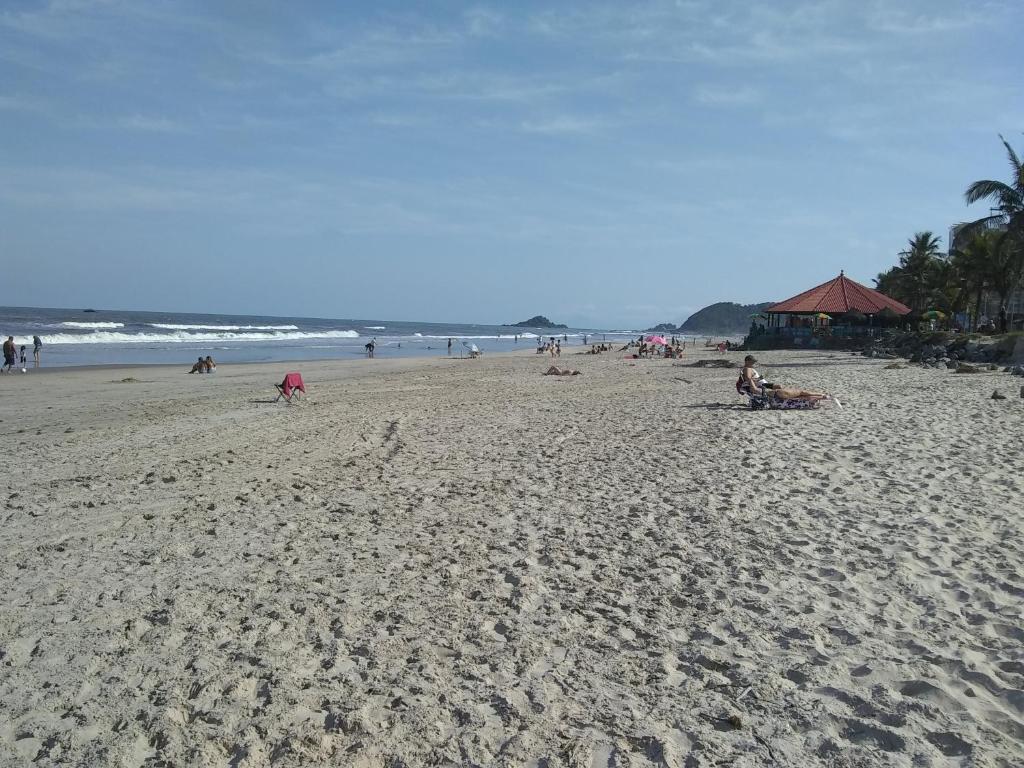 a group of people sitting on a beach at Apartamento à 50 metros da praia - Itanhaém in Itanhaém