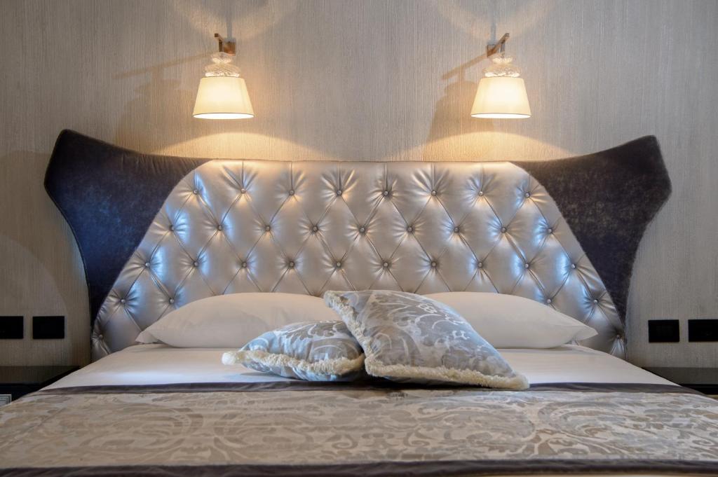 a bed with a blue headboard and two pillows at Palazzo Veneziano - Venice Collection in Venice