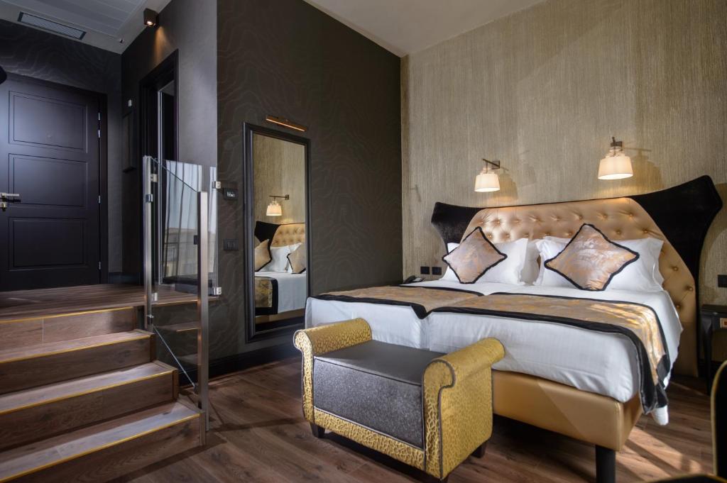 a bedroom with a king sized bed and a chair at Palazzo Veneziano - Venice Collection in Venice