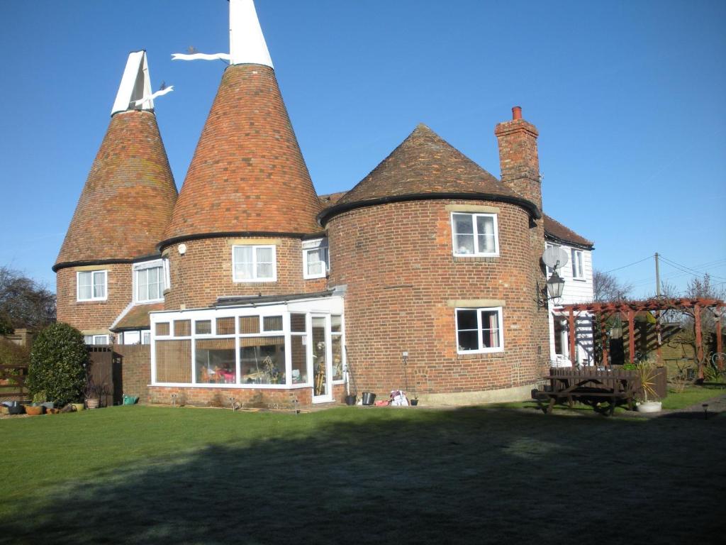 a large brick building with three chimneys on it at Manor Farm Oast in Winchelsea