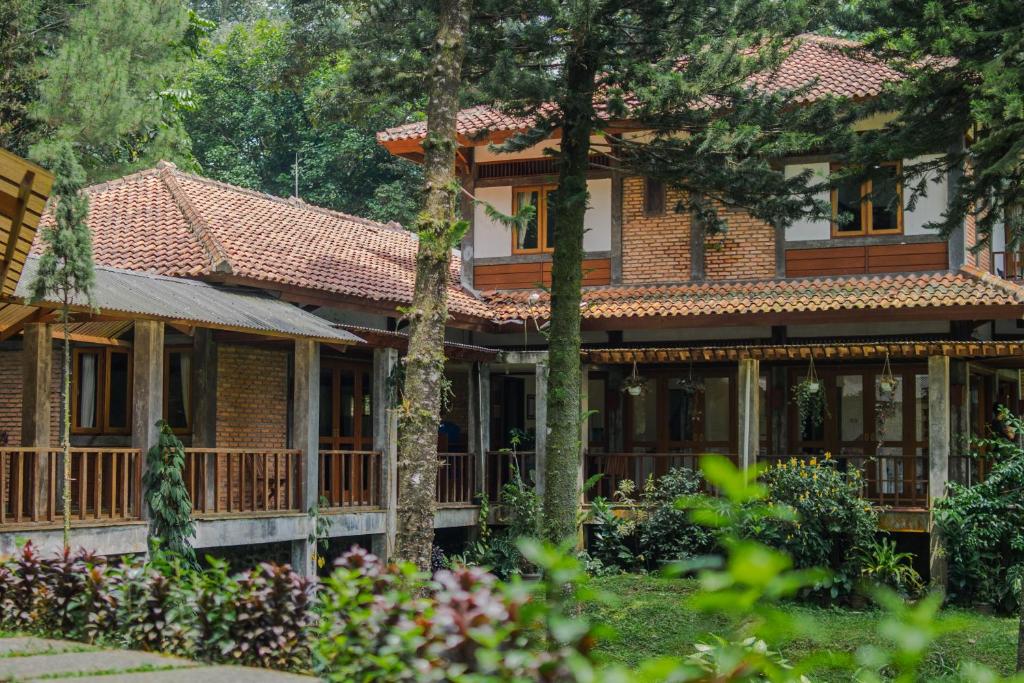 a house in the woods with trees and flowers at Griya Dunamis by SABDA in Puncak
