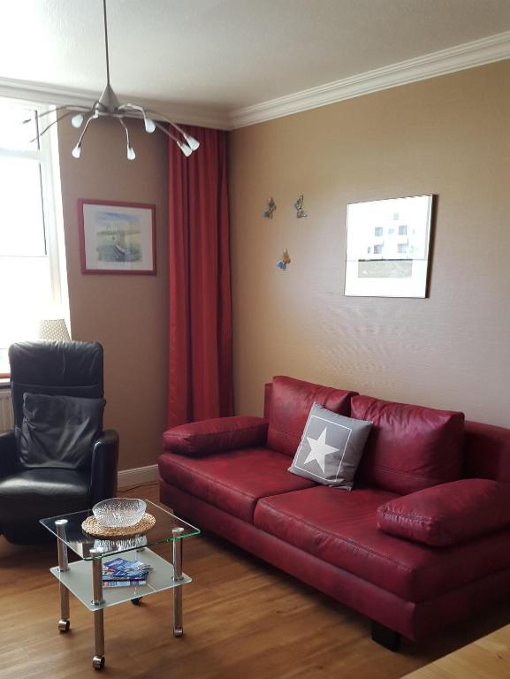 sala de estar con sofá rojo y silla en Karl-Theo-Am-Wald, en Westerland