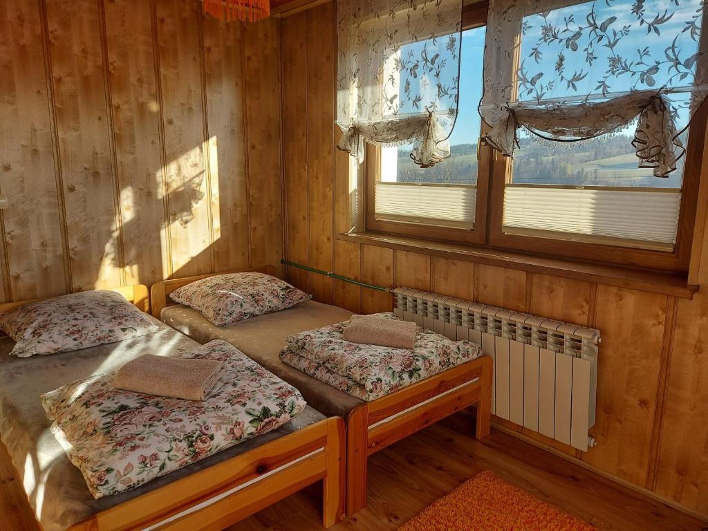 2 Einzelbetten in einem Zimmer mit Fenster in der Unterkunft Pokoje na Wierchu in Biały Dunajec