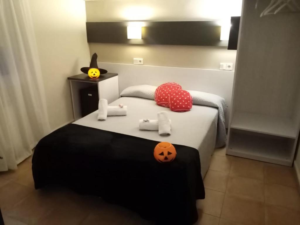 
a bed with a white blanket and pillows on it at Hostal Termes in Sitges
