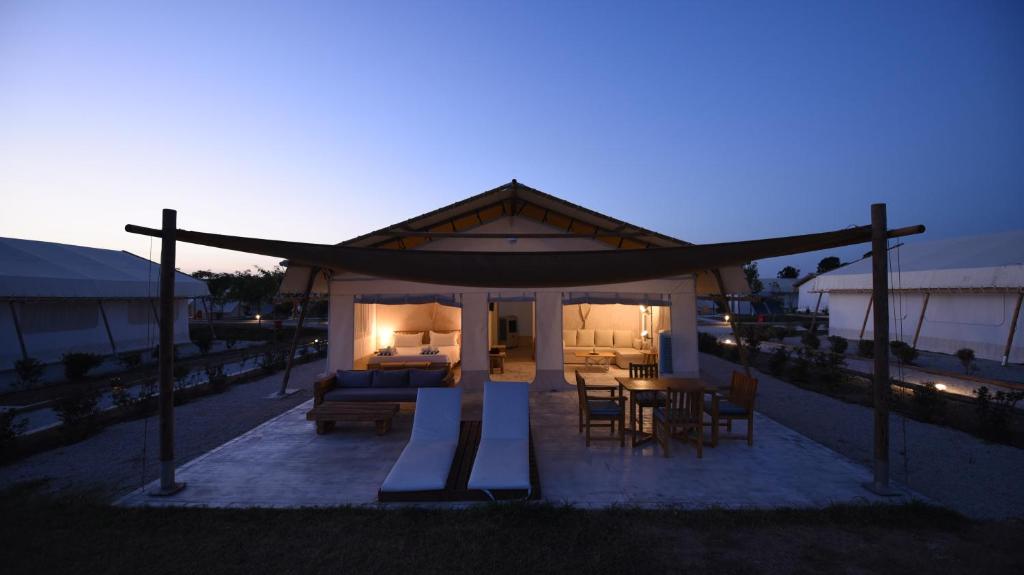 ein kleines Haus mit einem Bett, einem Tisch und Stühlen in der Unterkunft Sails on Kos Ecolux Tented Village in Marmari