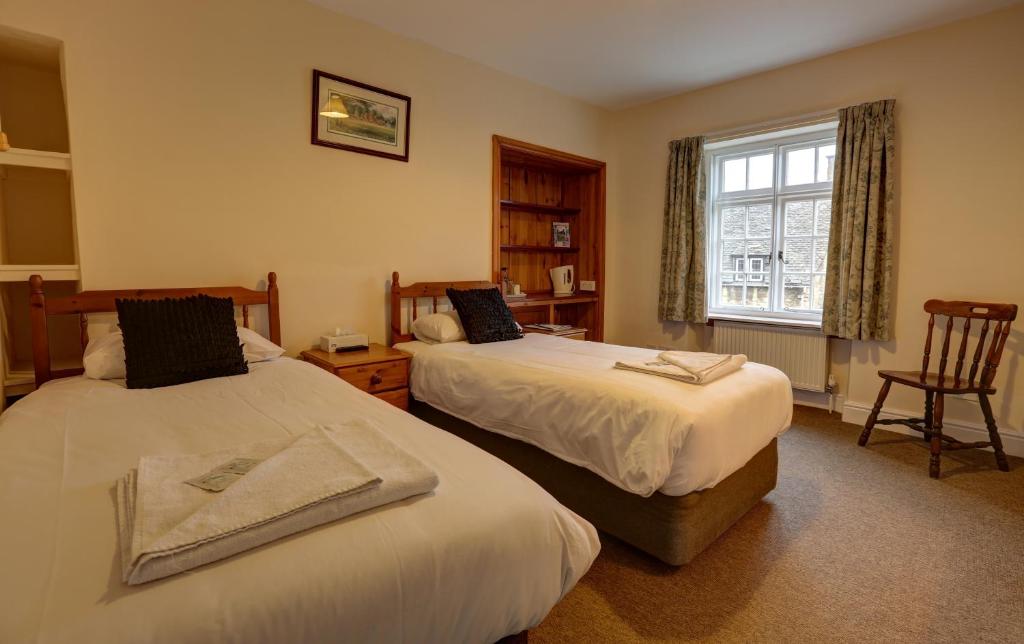 Habitación de hotel con 2 camas y ventana en Volunteer Inn, en Chipping Campden