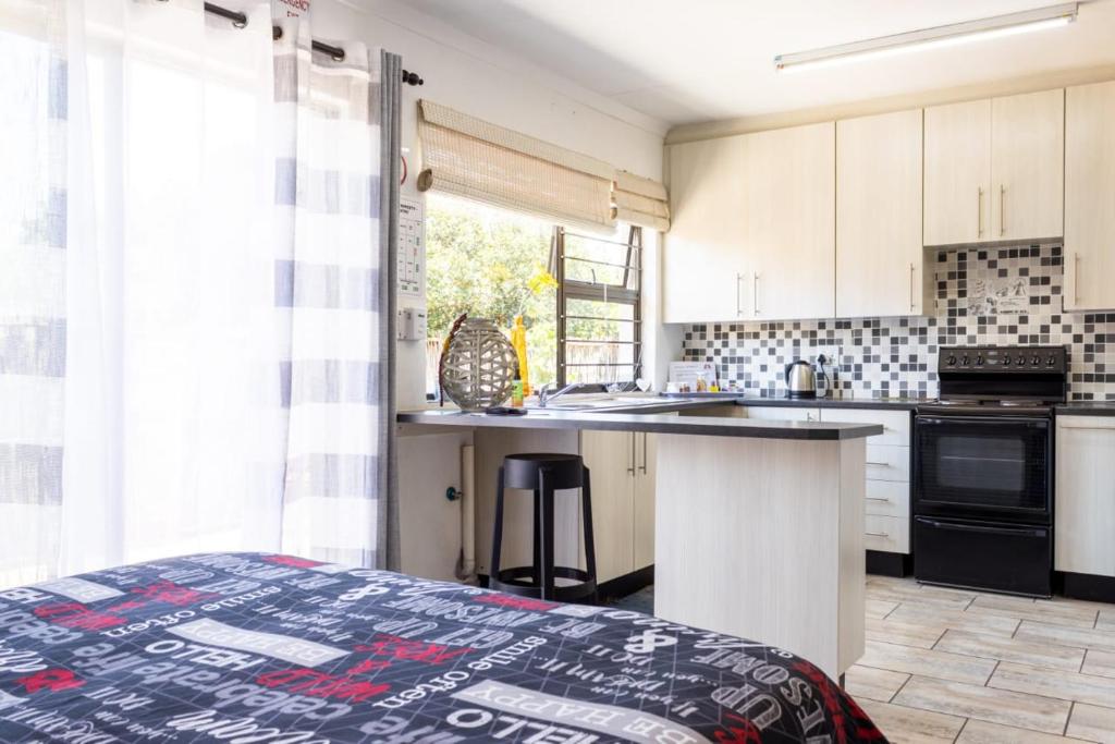 a kitchen with white cabinets and a counter top at MyKhaya-your home away from home in Kempton Park