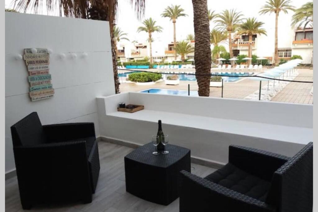 Habitación con 2 sillas, mesa y piscina en Perfect flat for your holiday at South Tenerife en Arona