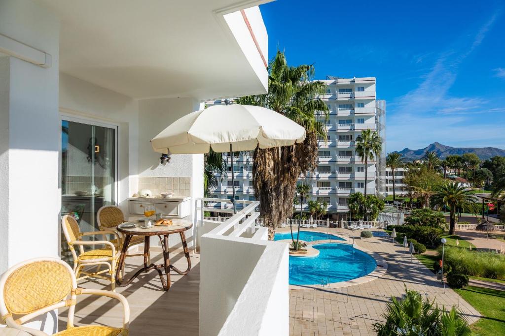 a balcony with a table and chairs and a view of a building at Apartamento Villa Cancun in Port d'Alcudia
