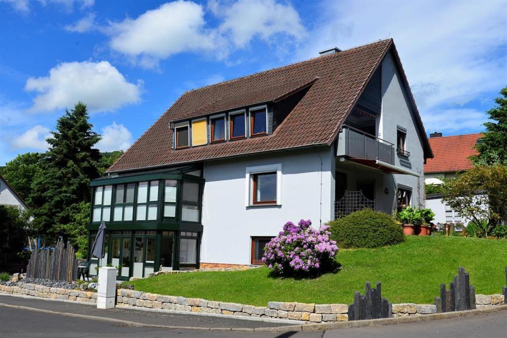 a large white house with a brown roof at Ferienwohnung Dittrich in Hilders