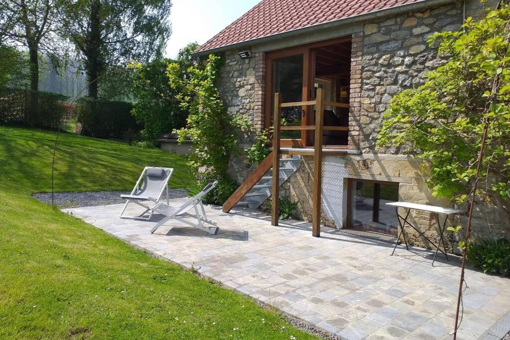 une terrasse avec 2 chaises et une maison dans l'établissement Gite de Miavoye, calme nature chaleur vue tennis, à Onhaye