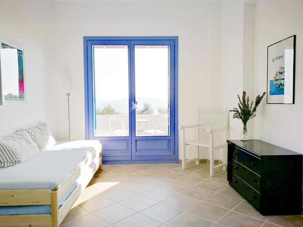 a bedroom with a bed and a blue door at Olive Bay Hilltop Apartments Ammouliani in Ammouliani