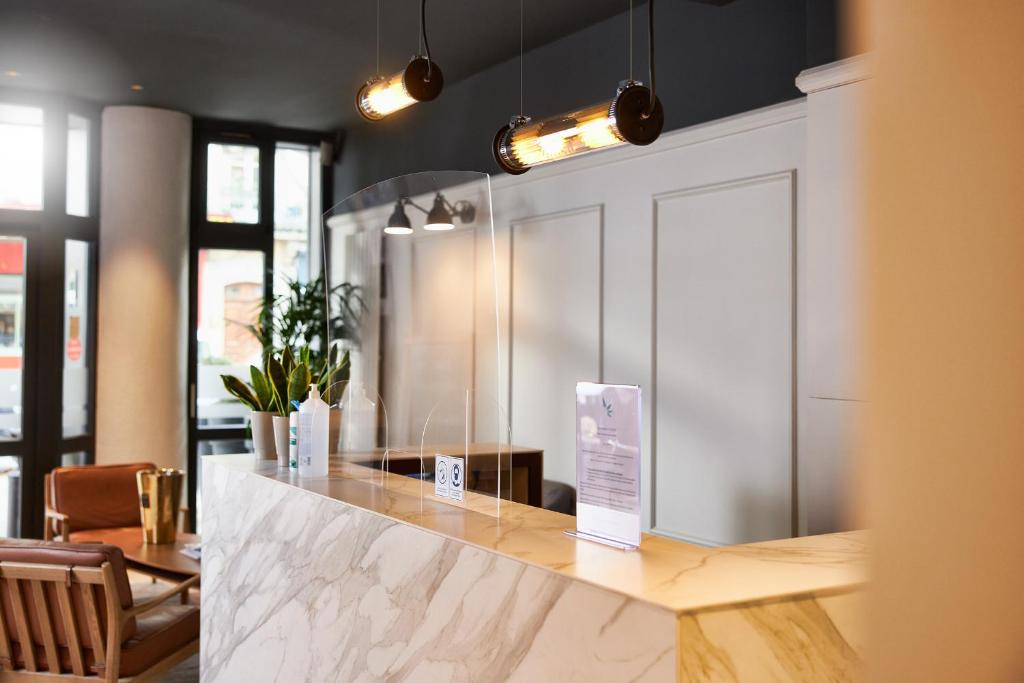 a kitchen with a counter with a sign on it at Hotel Les Negociants in Valence