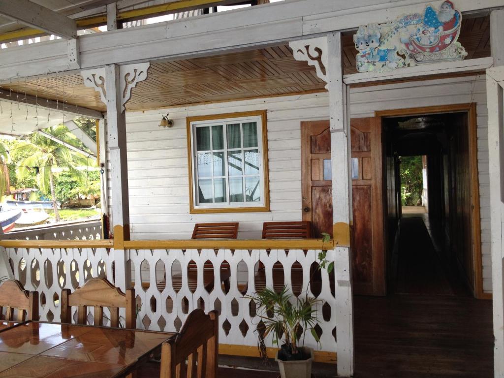 a porch of a house with a table and chairs at Hotel Caribbean View in Bastimentos