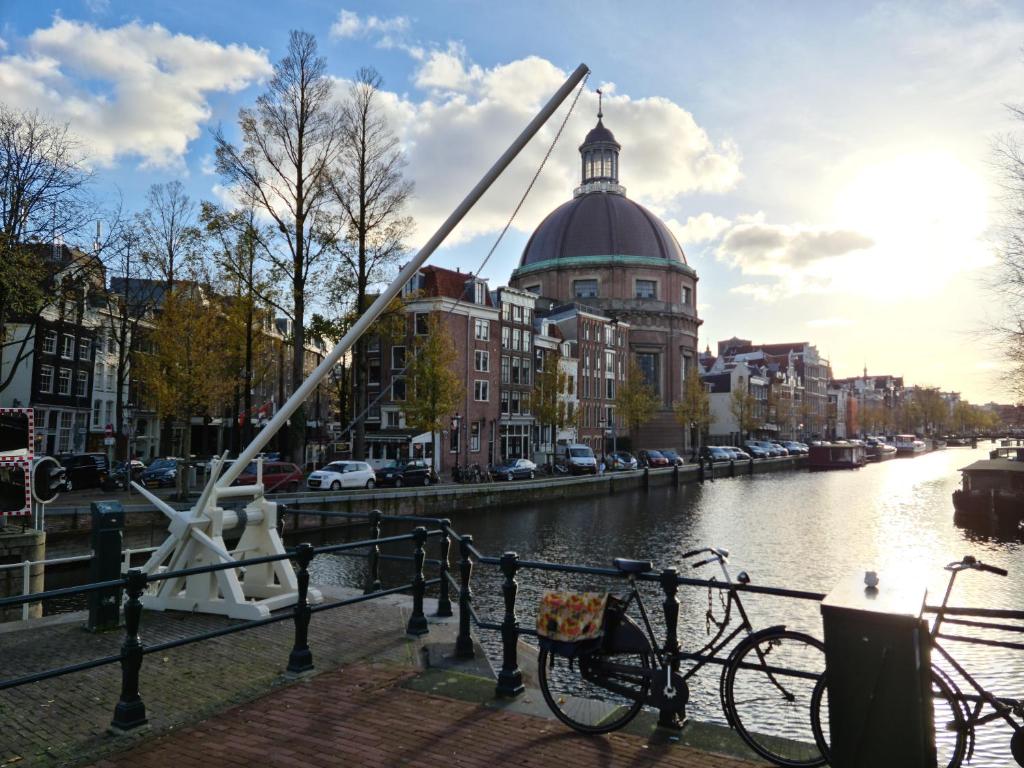 a bike parked on a fence next to a river at Canal view suite in Amsterdam