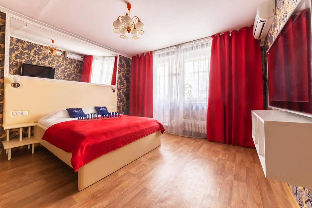 モスクワにあるApartment Hanaka Alma-Atinskayaのベッドルーム1室(赤いカーテン、赤い毛布付きのベッド1台付)