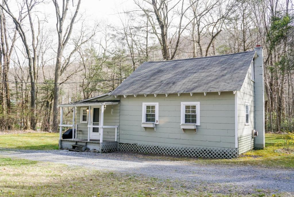 uma pequena casa branca na floresta em Camelback cottage - on ONE ACRE & near local attractions em Tannersville