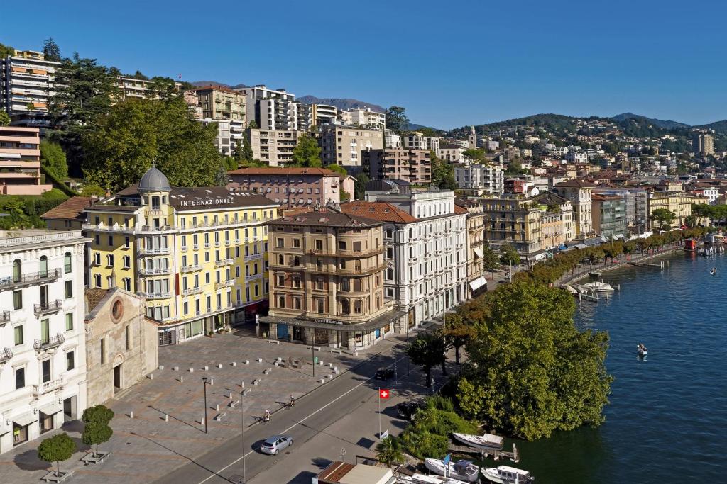 une vue aérienne sur une ville avec une rivière et des bâtiments dans l'établissement International au Lac Historic Lakeside Hotel, à Lugano