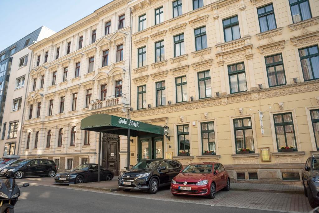 un gran edificio con coches estacionados frente a él en Hotel Adagio, en Leipzig