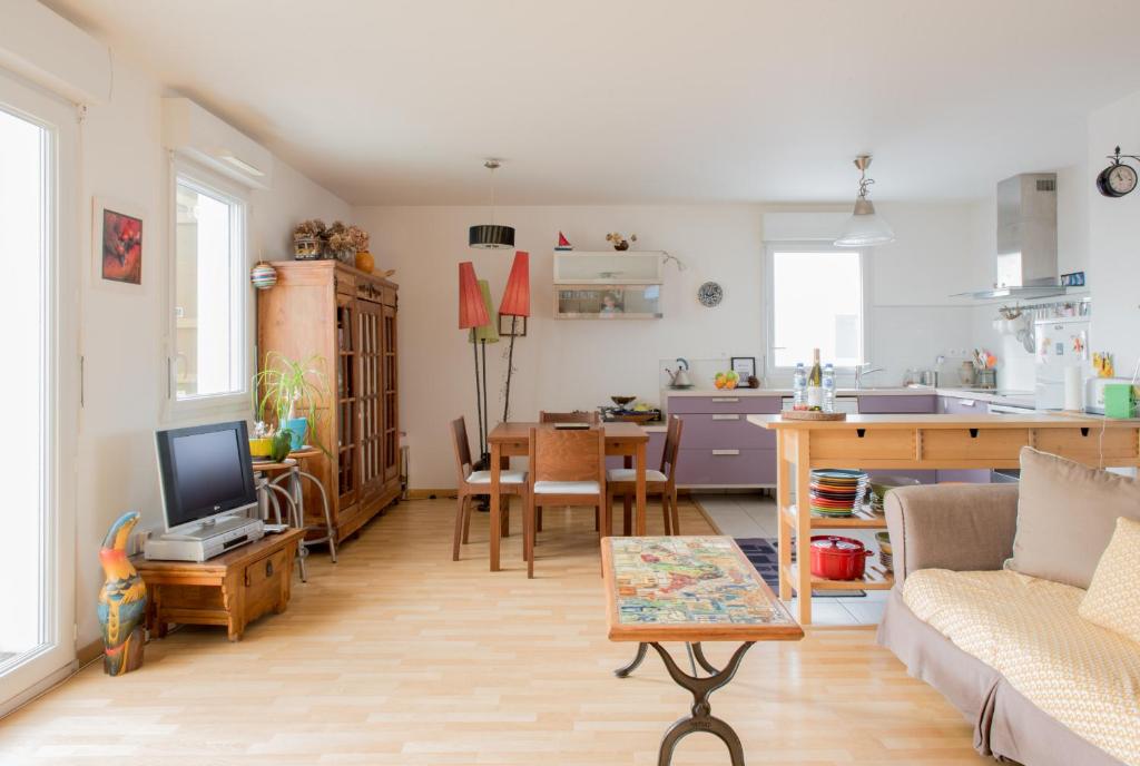 Il comprend un salon avec un canapé et une table. dans l'établissement LE VOYAGEUR - Appartement avec vue mer, à Saint-Nazaire
