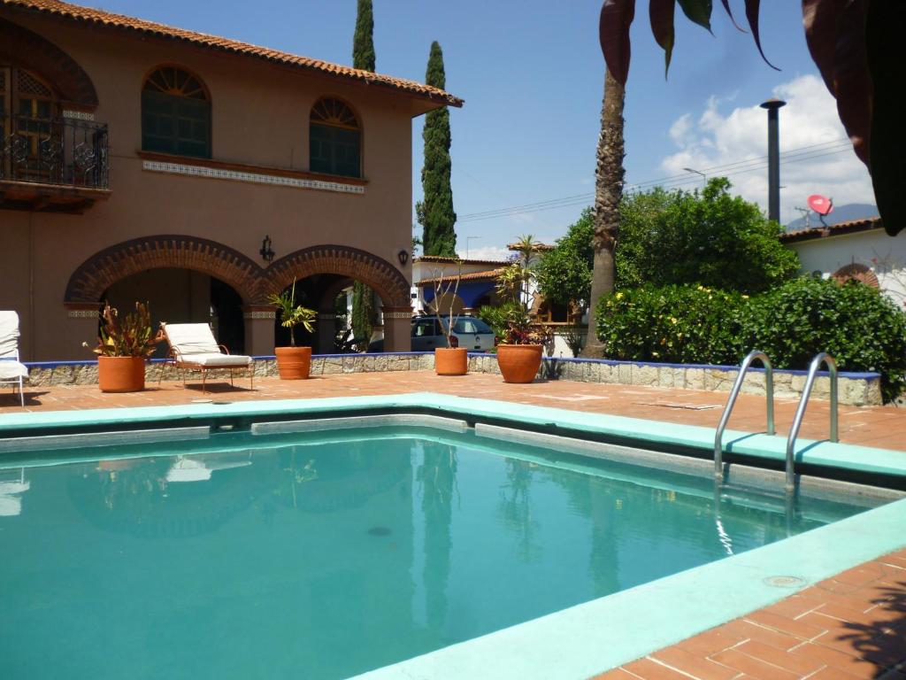 a swimming pool in front of a house at Hotel Posada Los Arcos in Oaxaca City