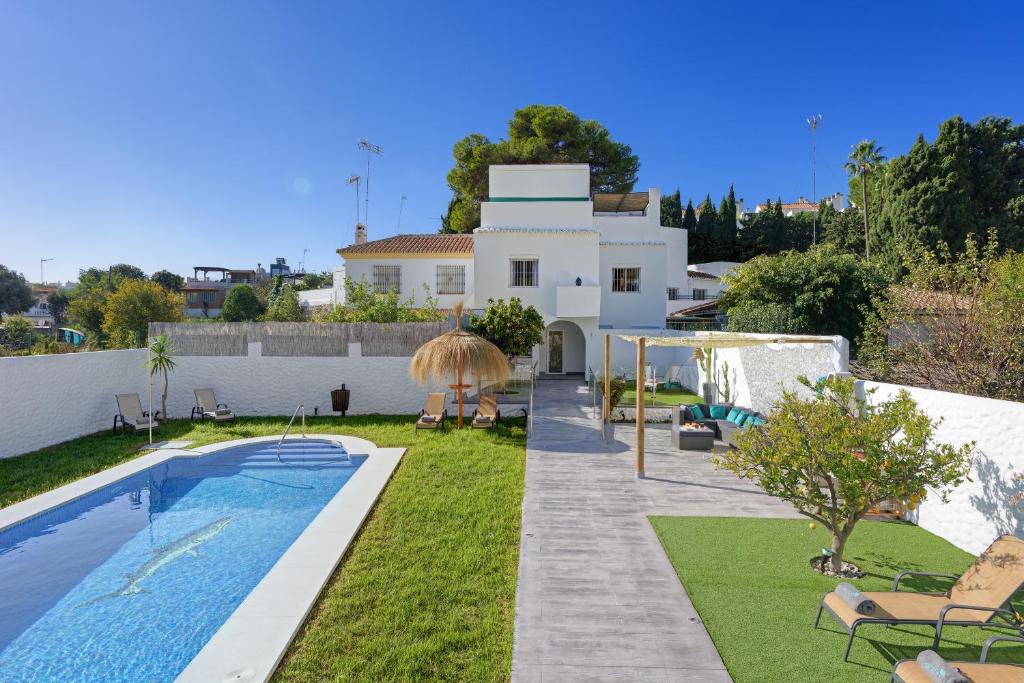 a backyard with a swimming pool and a house at Villa Mamba By Seric,15' walking to the beach in Torremolinos