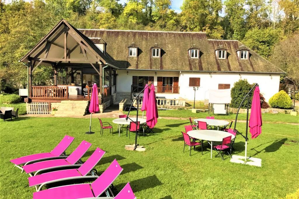 een groep roze stoelen en tafels voor een gebouw bij Le domaine du Lac in Villecerf