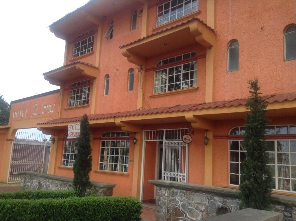 a large orange building with a lot of windows at Hotel La Loma in Huasca de Ocampo