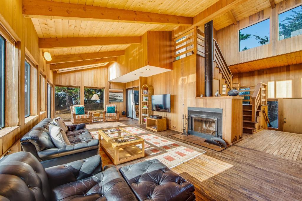 uma sala de estar com mobiliário de couro e uma lareira em Albatross Reach em Sea Ranch