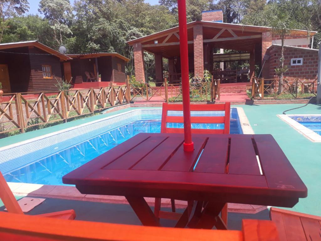 una mesa de picnic frente a una piscina en Cabañas La Quinta en Puerto Iguazú